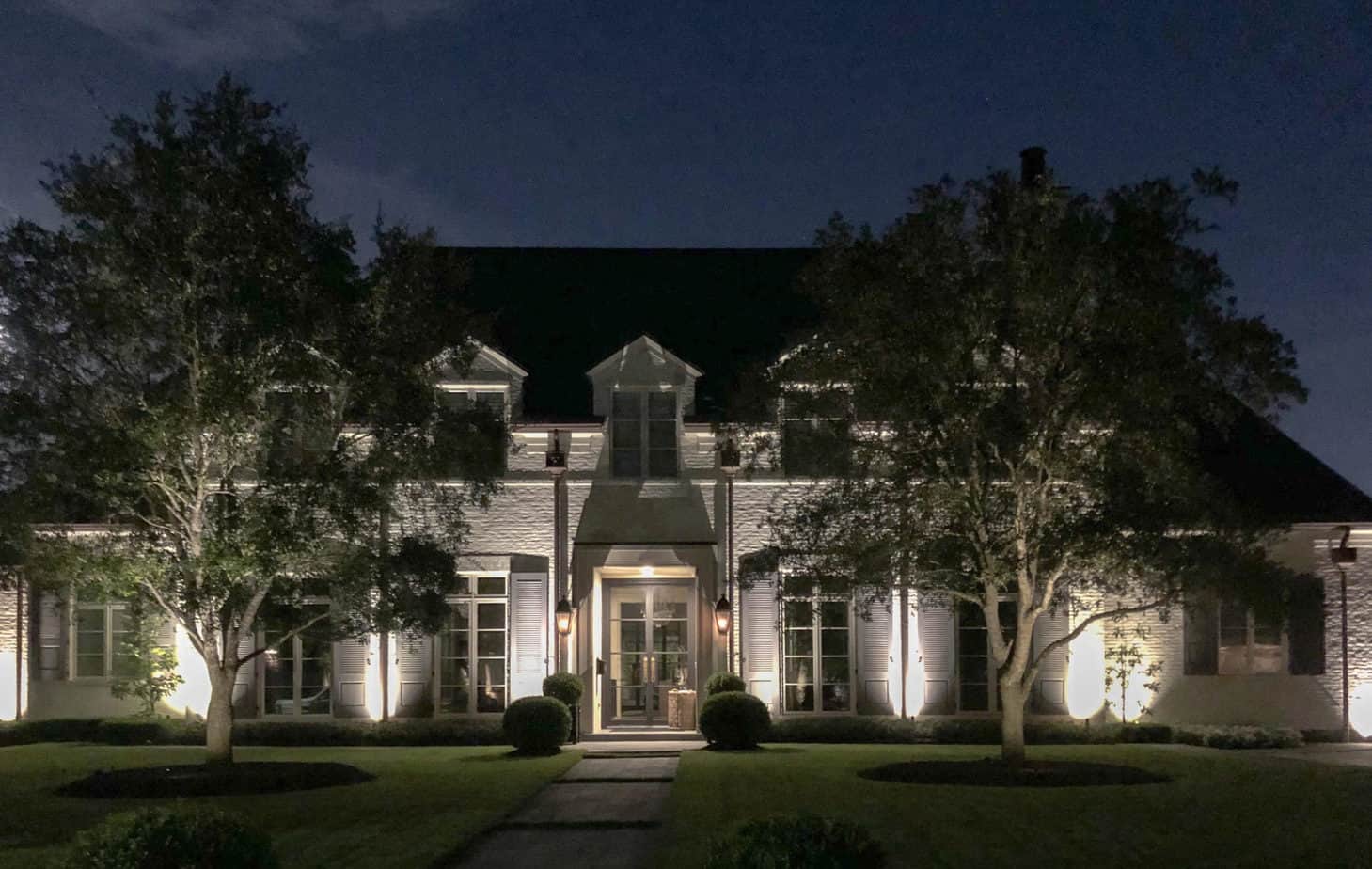 Outdoor landscape lighting on a colonial style house on a