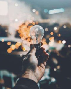 Energy efficient outdoor LED lighting bulb against a sky of twinkly lights
