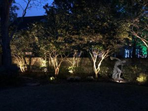 Lighting techniques like shadowing, casts the shadows of trees and statues against a wall at night.