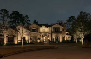 Memorial Villages Houston Tx home, the Traditional village homestead is a two story, lengthy home lit up at night. 