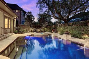 A beautiful pool sits under trees, creating an outdoor haven