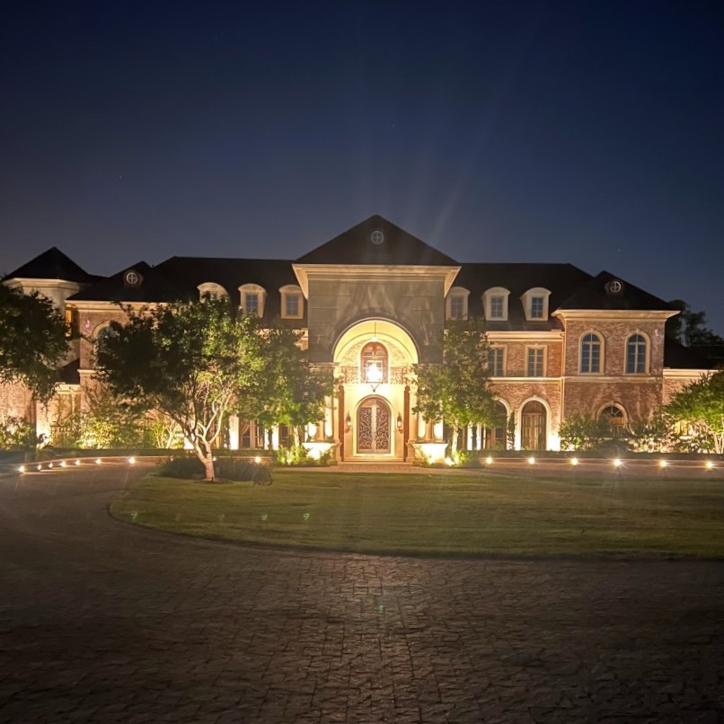 Led light system well lit alcove of large home with driveway and lawn