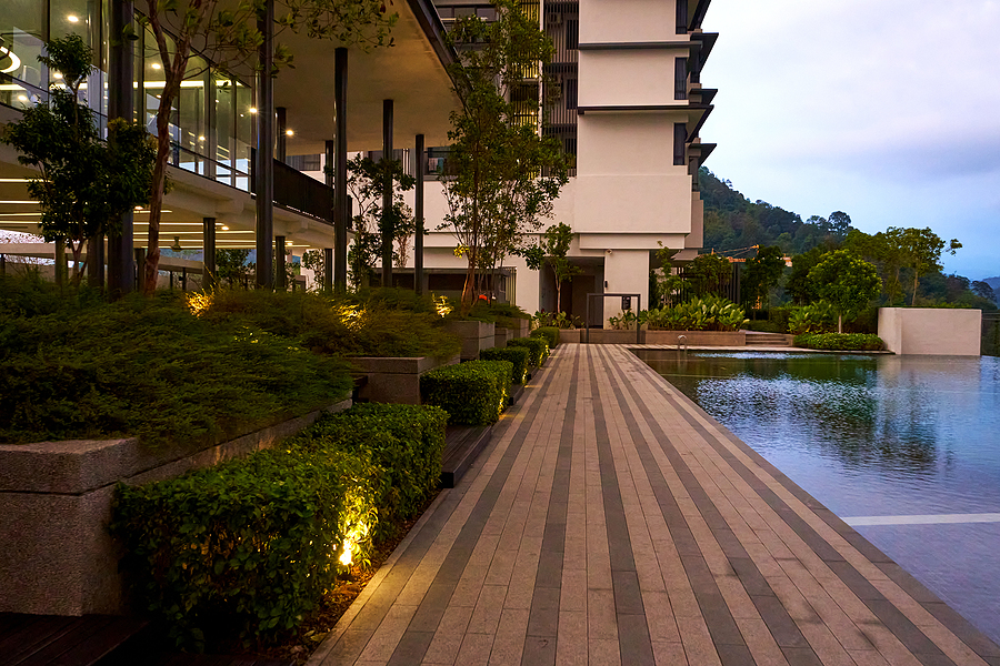 Exterior of condos with landscape lighting along walkway outside of pool
