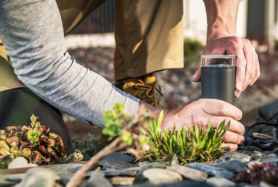 Closeup of Outdoor Garden Lamp Being Installed by Professional Gardener to Provide the Illumination to Landscaped Backyard. installing outdoor lighting
