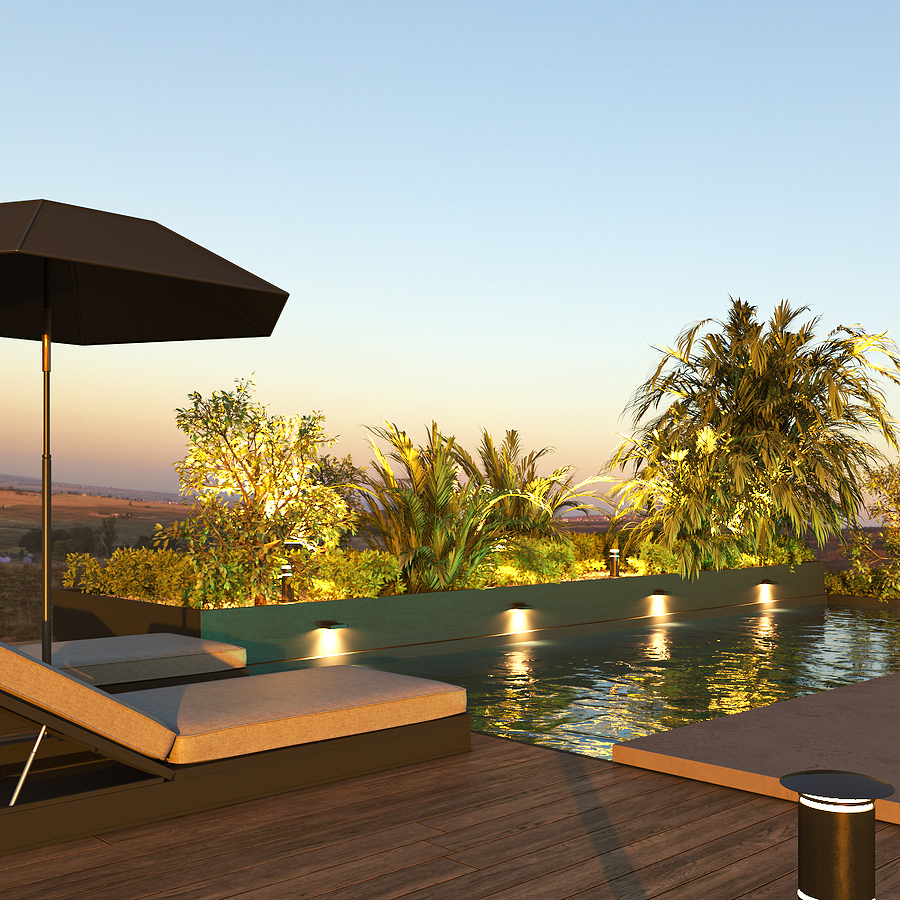 Modern pool with pool lights, lounge chairs, and greenery at sunset.