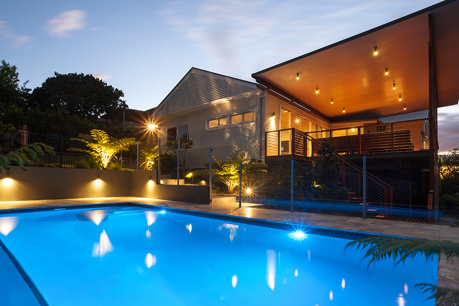 Hotel with flashing lights around the pool at night with lite sky , there are dark areas around the house with tree forest garden. Why Pool Lighting For Safety Is Essential