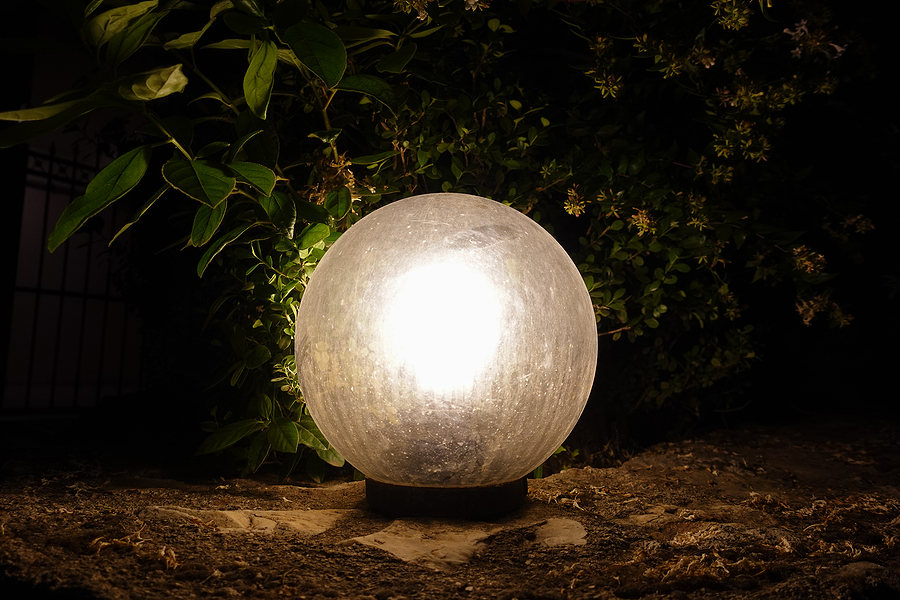 White outside lighting, globe light on floor of garden.