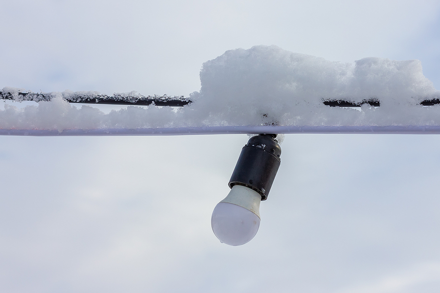 LED lamp on a wire. Wire covered with snow. Street lighting in winter.. Cold weather