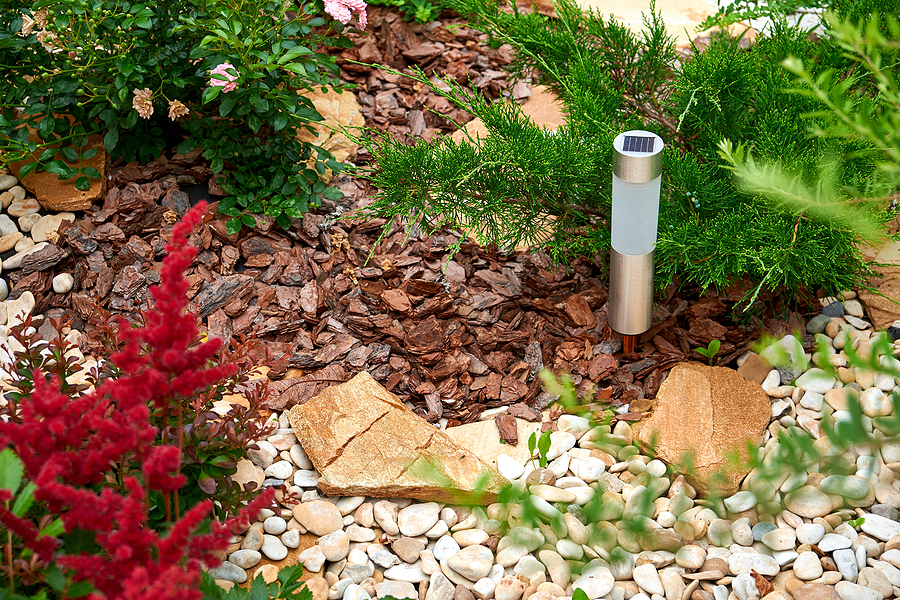 Garden Design. Solar Garden Light. Lanterns in Flower Bed In Green Foliage. Solar Powered Lamps. wireless