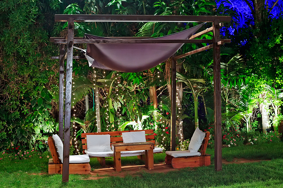 Backyard lounge area among grass and tress for an at home staycation.