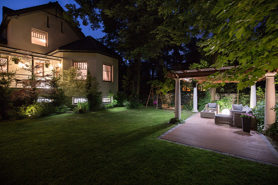 Luxury residence with a beautifully lit patio showcasing the benefits of outdoor lighting for safety, ambiance, and curb appeal.