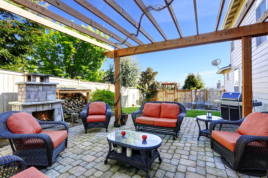 Cozy small backyard with patio seating and outdoor fireplace.