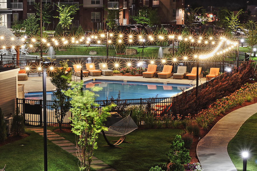 Illuminated apartment pool area at night showcasing the right outdoor lighting for tenant safety.