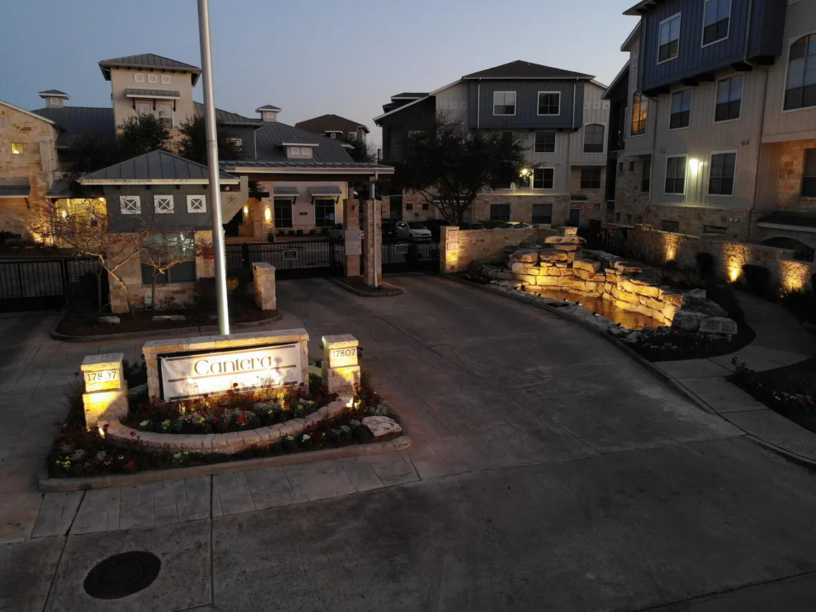 hl-area-ec-entry-1180.webp Entrance drive of a commercial property with lit monument signage and building facades