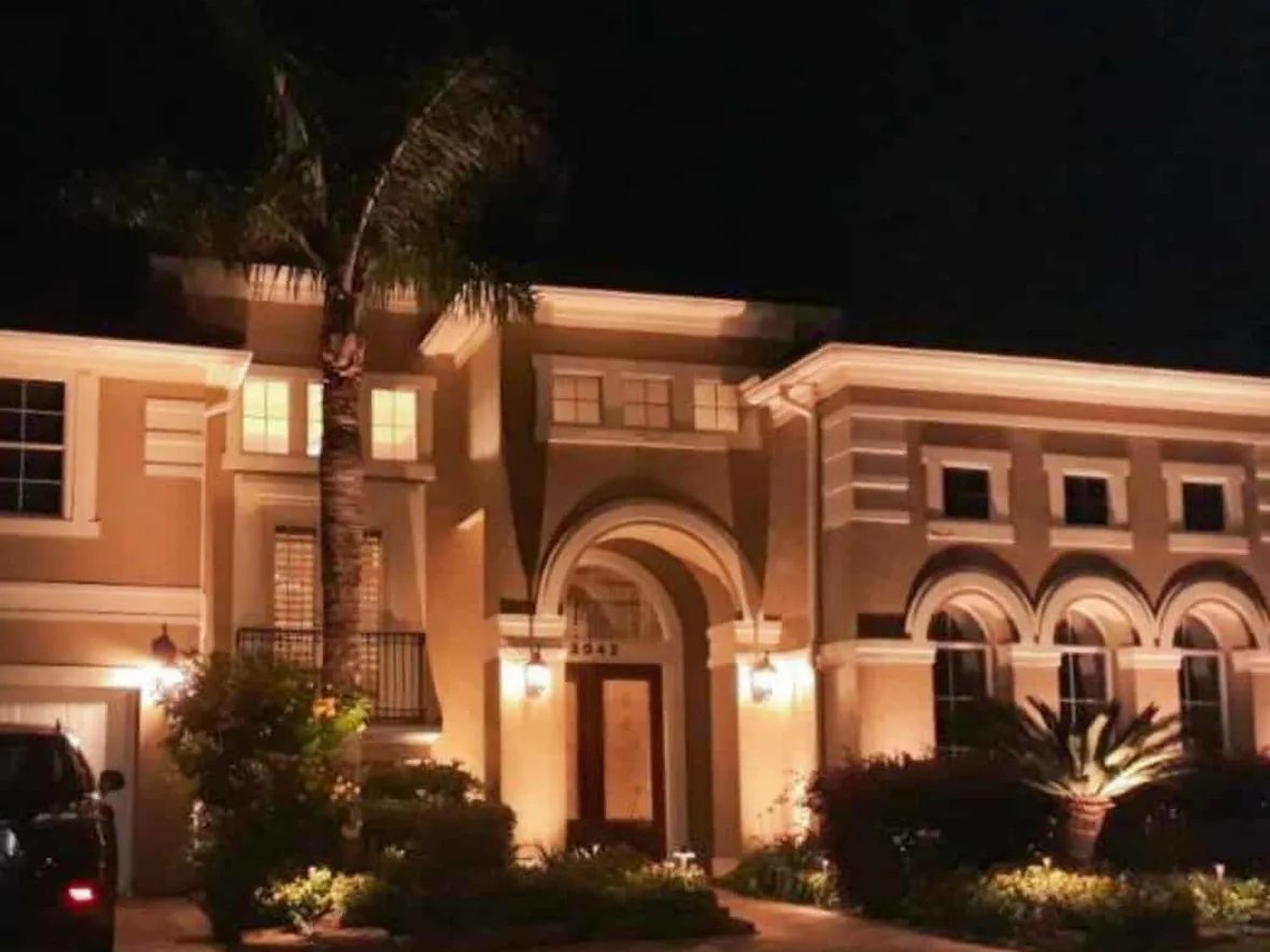 hl-path-entry-palm-1180.webp Front entry with uplit palms and a lit walkway leading to the door