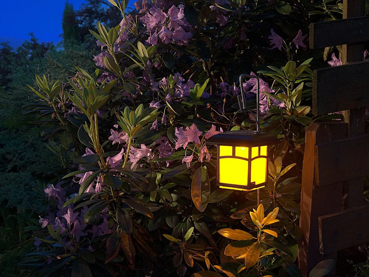 hl-patio-lantern-1180.webp Garden lantern and planting beside a seating area, lighting the space from the side rather than overhead