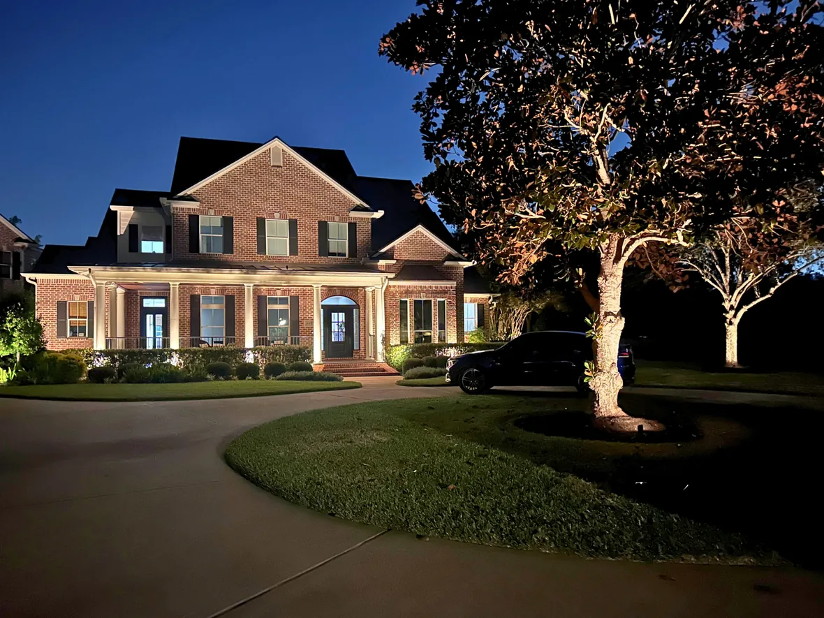 hl-res-led-system-1180.webp Stone facade and landscaping lit with low-voltage brass fixtures hidden in the planting beds
